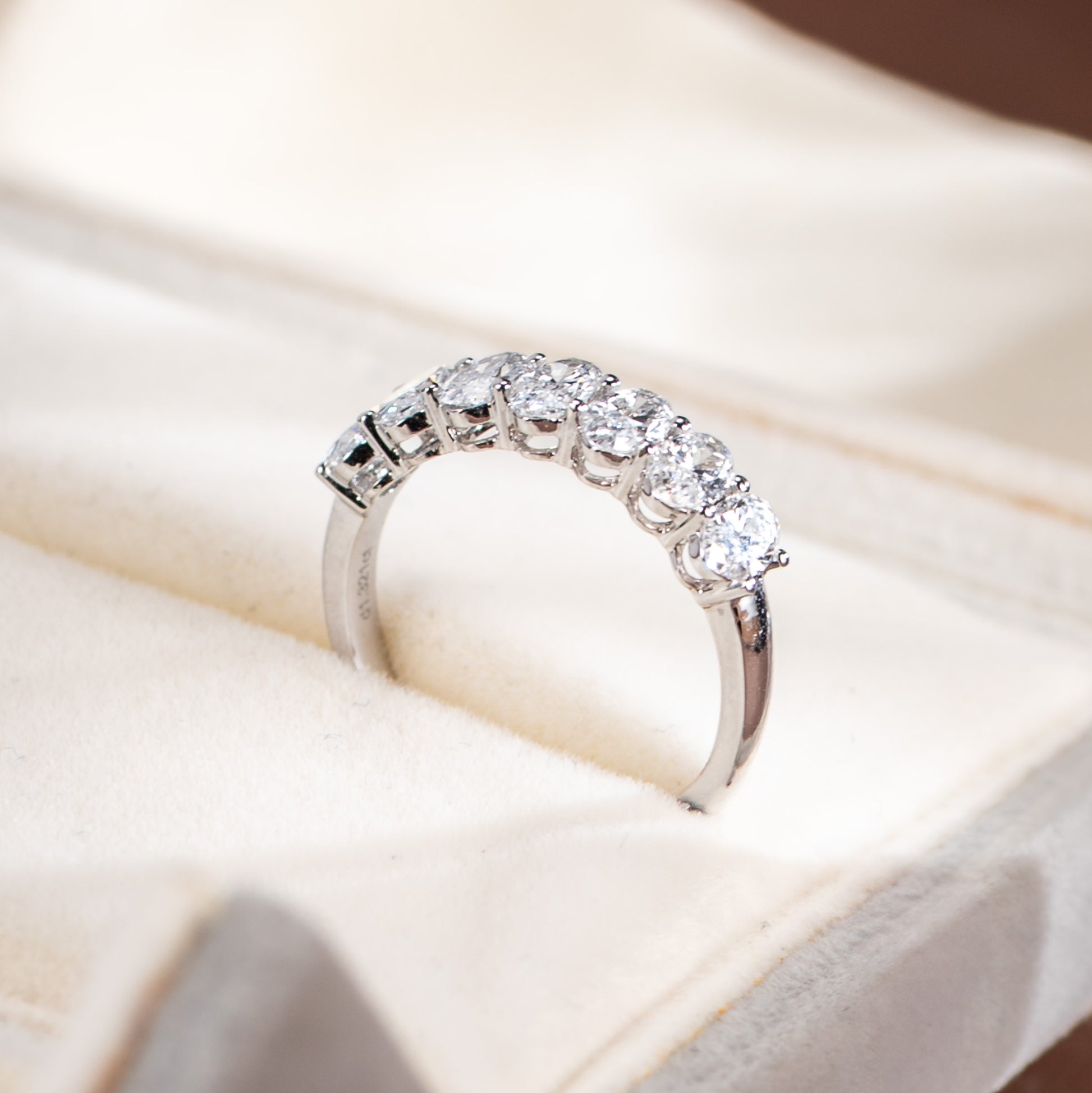 Silver ring with diamonds on a soft beige background