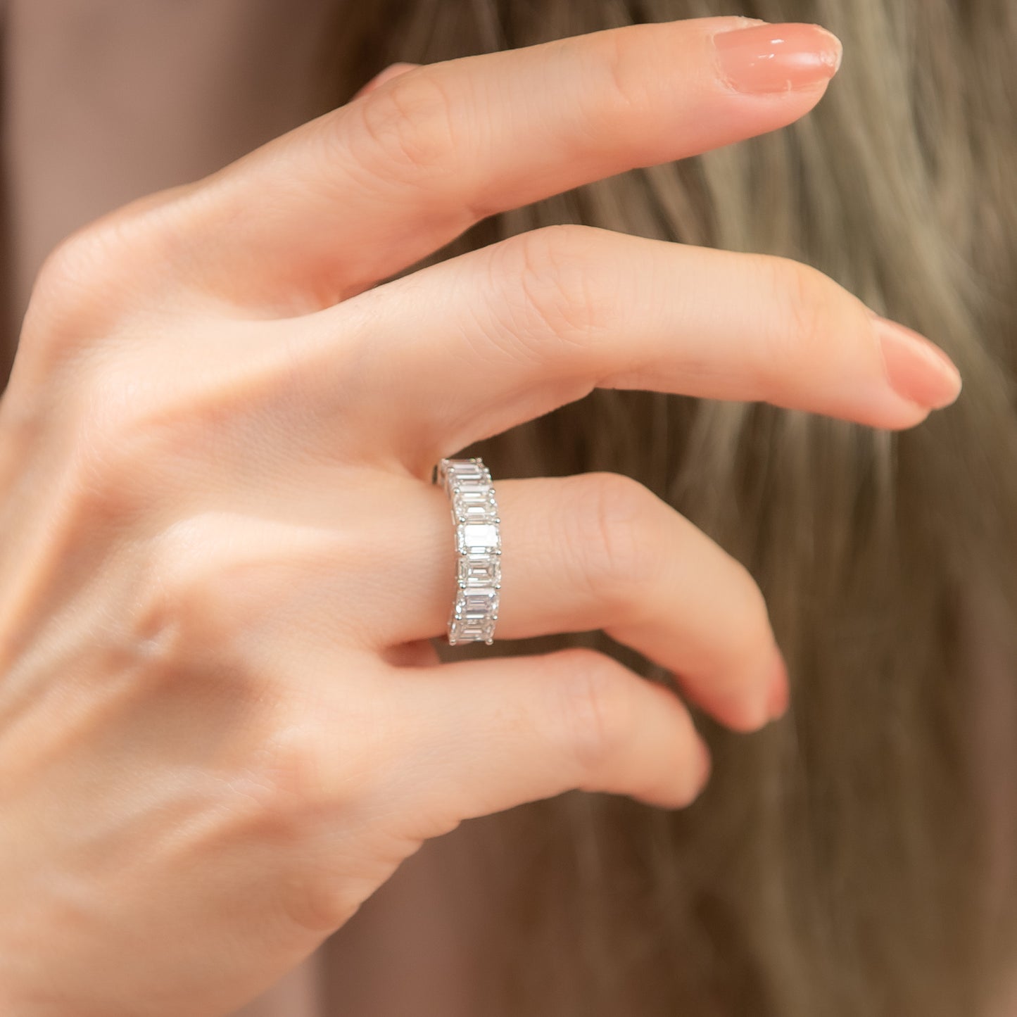 Close-up of a hand wearing a silver ring with a blurred background