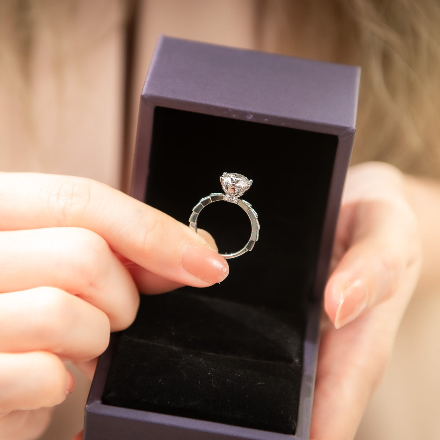 Silver ring held by a person with a blurred background