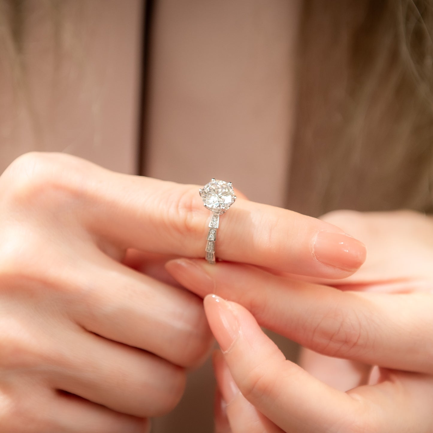 Close-up of a hand wearing a diamond ring with a soft background