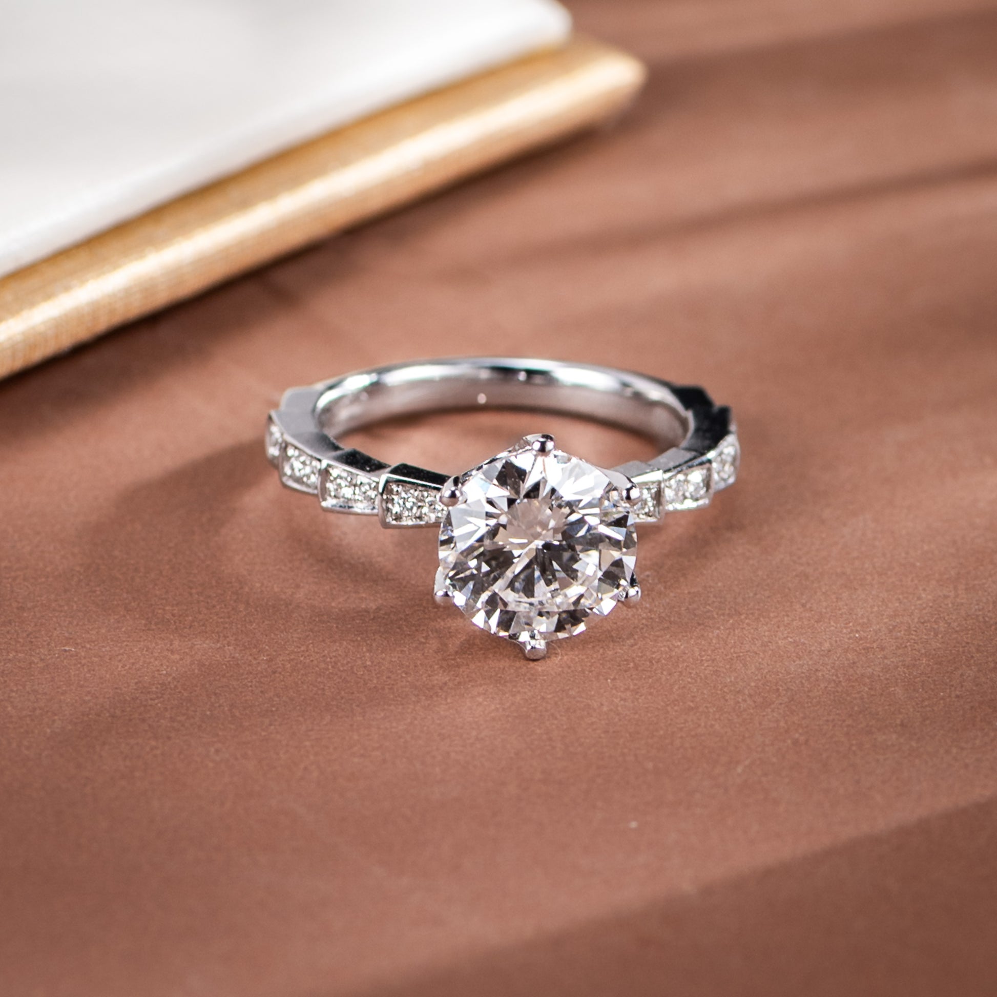 Silver diamond ring on a brown fabric background