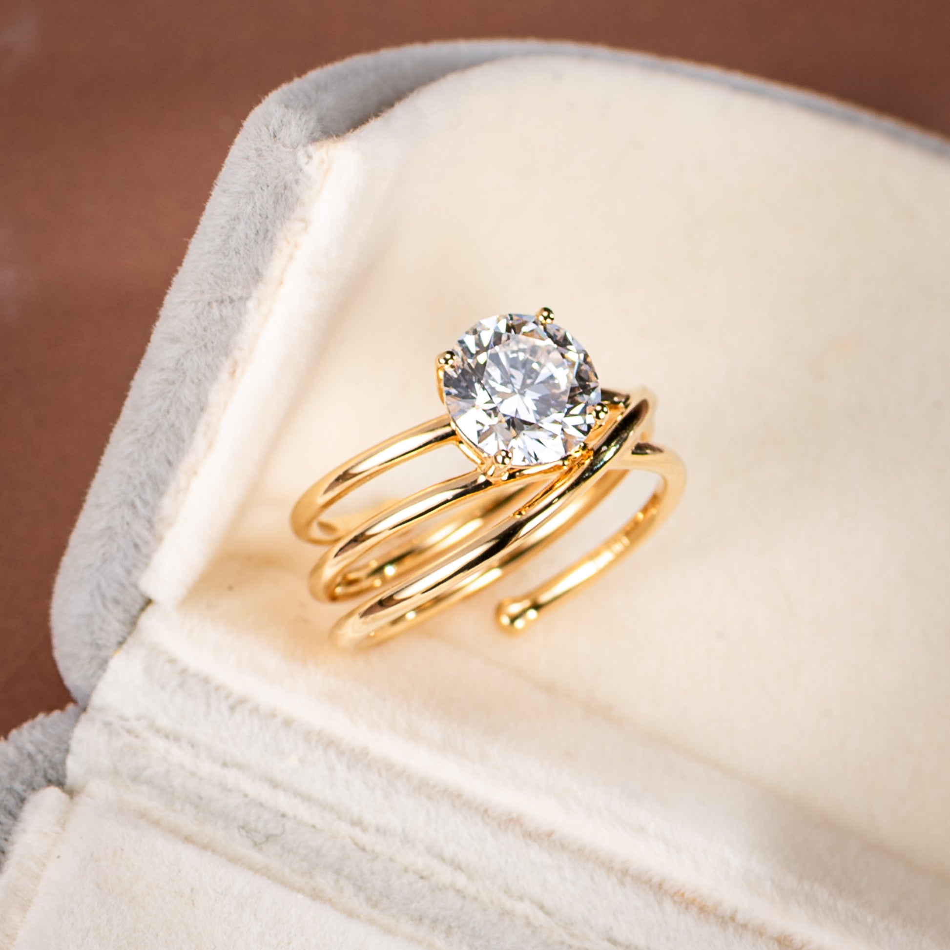 Gold ring with a diamond on a soft fabric background