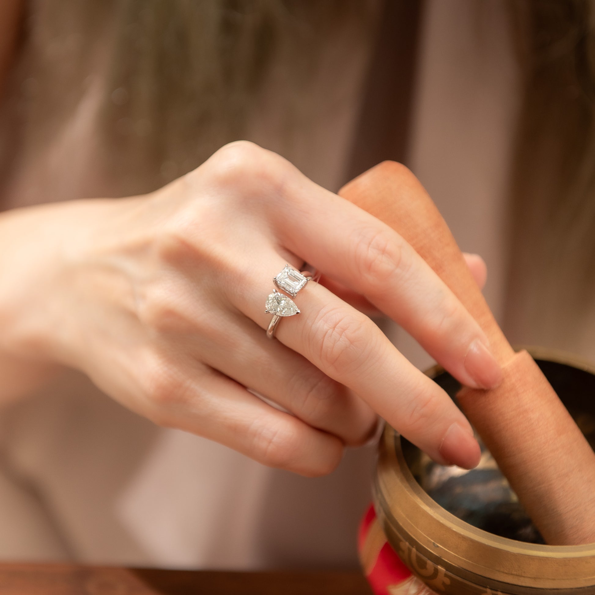 Close-up of a hand wearing a diamond ring with a blurred background
